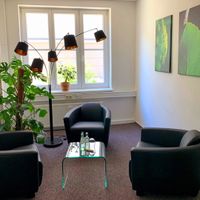 Coaching- und Mediationsraum Köln: 3 Sessel, ein Tischchen, eine große Lampe, Pflanzen, Bilder an den Wänden